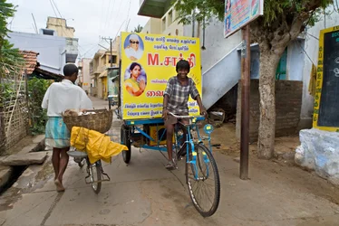 Boy on Poster-Bike in Narrow Street Canvassing for Party Political Elections